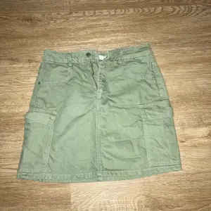 Grön jeans kjol med fickor på sidorna. Har använts enstaka gånger och har en lite lösare passform.