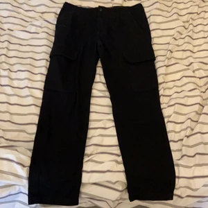 Ett par svarta byxor i storlek EUR 40/USA 31 - Säljer detta par svarta byxor från Pull&Bear som passar så bra till alla slags outfits och i alla stilar. Från streetwear till emo/punk! Om du köper byxorna så kommer också en svart kedja med på köpet gratis! 