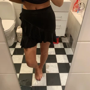 Volang kjol i trikå  - Svart volang kjol från H&M i trikå material som formar sig fint efter kroppen. Nästintill oanvänd i storlek XS, men passar mig som har S och för att den är i trikå passar den även andra storlekar. Hör av er vid frågor:) 