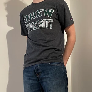 Vintage Champion t-shirt - Skitcool vintage Champion t-shirt med trycket ”DREW UNIVERSITY”. Storlek M och mörkgrå färg. Priset är 200kr + frakt!