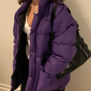Lila pufferjacka!! - Supernajs lila pufferjacka från DeauVille! Väldigt stor o puffig (min kompis som modellar är 160 lång o är en storlek S! Jackan är i M men man får plats med lager under! Väldigt varm och perfekt nu för vintern!!