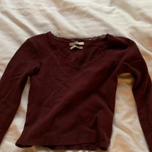 Gullig vinröd v-ringad tröja🥰 - Söt topp med spets i v-ringningen perfekt nu till julen! Köpt på Pull & Bear i Mos för ett år sedan ungefär. Nypris 69kr- säljer för 20kr! Jag skulle säga att det är en XXS eller XS!💕