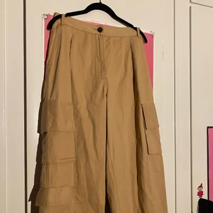 Cargo pants - Beigea cargo pants från monki. Köpta second hand men har bara använt de en gång då de är för stora för mig:( Väldigt vida och har totalt tre fickor på benen. Kan skicka fler bilder.