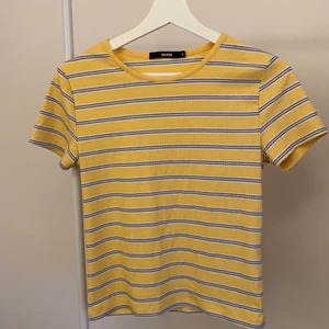 Gulrandig tröja - Gul T-shirt med blåa ränder. Verkligen jättefin men kommer inte längre till användning hos mig. Skicket är fint trots normal användning. Frakten är inkluderad i priset. Skriv privat vid frågor 