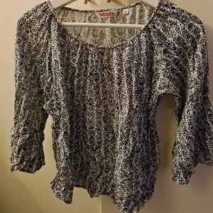 Blommig blus / topp med vida ärmar Strl M - En söt blus/ topp från indiska med blått blommigt mönster. Strl M men passar en S med. Katt finns i hemmet!