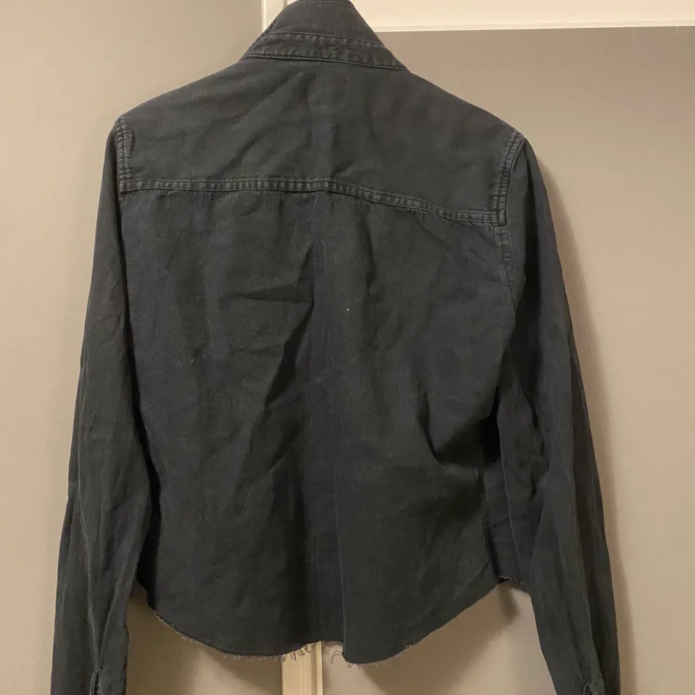 Säljer denna halv kroppade svarta jeans skjortan, används snyggt både öppen som stängd. . Skjortor.