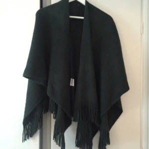  - Poncho mörkgrön i mjukt material. Aldrig använd.