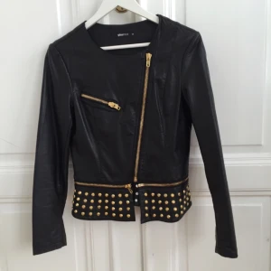  - Jacka i läderimitation med gulddetaljer. Endast använd ett fåtal gånger. Gina Tricot stl 34