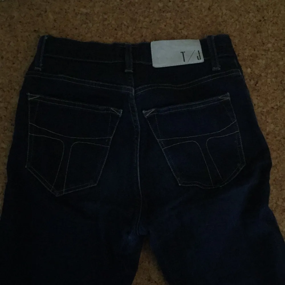 Mörkblå Tiger Jeans med högmidja. Något slitna samt uppsydda några cm.. Jeans & Byxor.