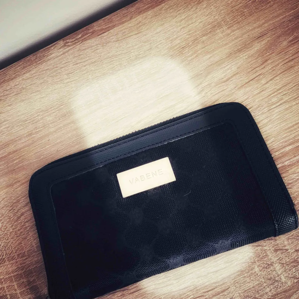 Plånbok i svart tyg med gulddetaljer med flera fack som försluts med dragkedja, använd ett fåtal gånger 🍂🍁. Accessoarer.