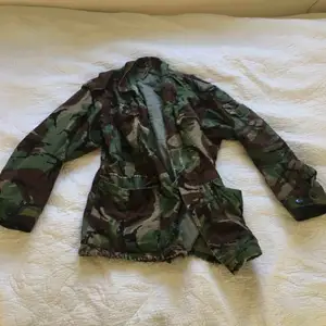 Cool militärmönstrad jacka, perfekt till hösten! En del mindre slitage, går dock ihop med designen :)