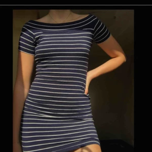  - Randig vit/ marinblå åtsittande off shoulder klänning. Använd ett fåtal gånger! 