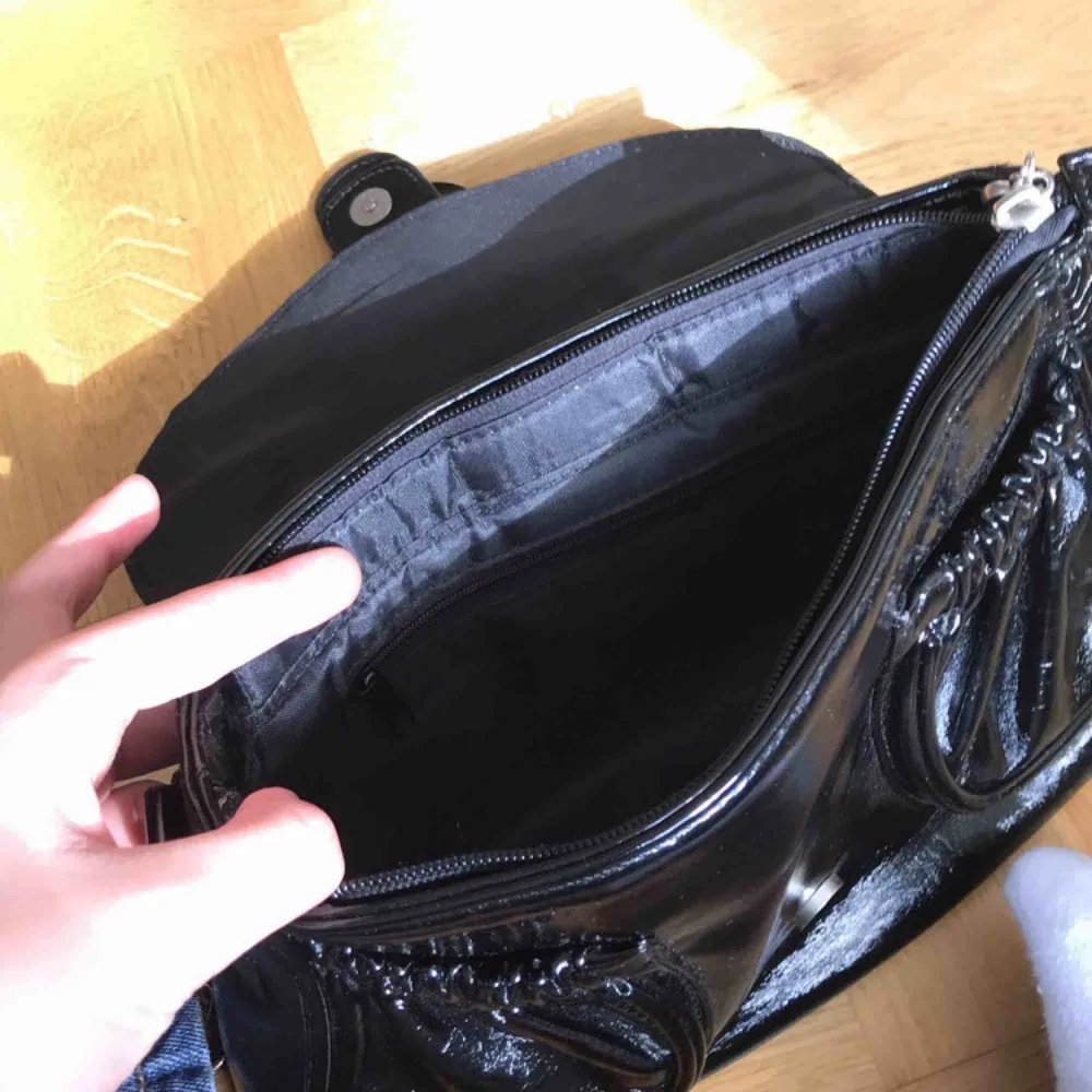 Liten handväska köpt secondhand men i superbra skick! Svartglansig med silvriga detaljer och mycket utrymme! Köparen står för frakt kostnader!🥰BUD 170kr!!!. Väskor.