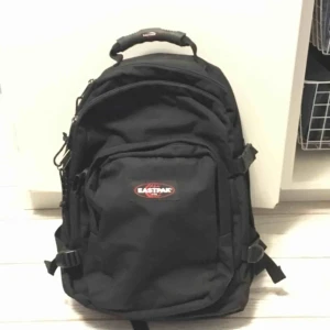  - Svart Eastpak ryggsäck ”Provider” i superfint skick! Använd cirka 5 gånger. Många bra fack. Ett stort fack inkl vadderat laptopfack. Ett mellanfack och ett mindre med småfack i. Spännremmar på varje sida. Vadderad rygg och bärremmar. Nypris cirka 900:-