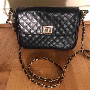  - Axelbandsväska från ASOS. Använd ett fåtal gånger. Väska är ca 23 cm bred, 16 cm hög och 8 cm djup.  Det främre spännet har lite repor men det syns endast när väskan är öppen 