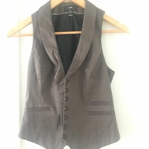 Väst - Elegant väst med dekoationsknappar. 