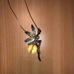  - Ett halsband: Kedjan är i färgen guld och figuren på halsbandet är en fe. Små diamanter lite överallt och en fin present till någon i en yngre ålder :)