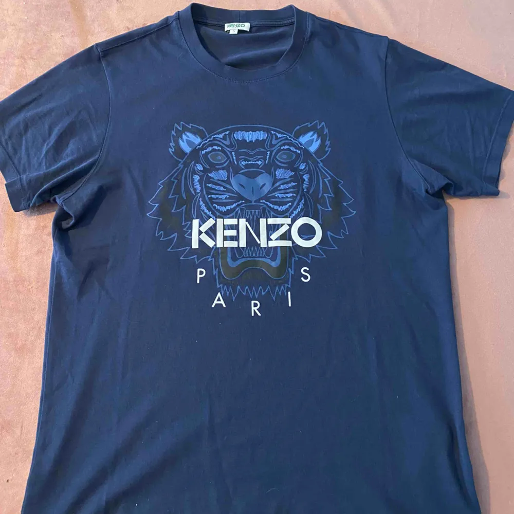 Blå tshirt med blå tiger från Kenzo. Plagget är i nyskick då den endast är använd ett fåtal gånger.. T-shirts.