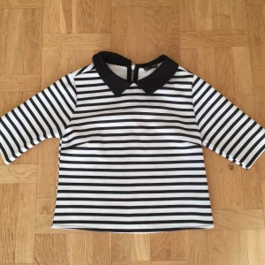 Fin randig topp med krage - Svartvit randig topp med krage. Lite kortare modell och jättefin på. Dragkedja i nacken. Knappt använd pga fel storlek för mig 