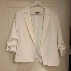  - Vit kavaj med rynkad arm 