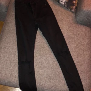 Gina Tricot byxa - ”High Waits Molly jeans” i svart med slitningar vid knäna, ifrån Gina Tricot funkar som Xs/S