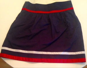  - Blå kjol med vita och röda ränder. Midjemått 74 cm. Aldrig använd. 