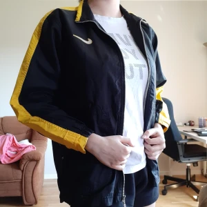 Nike jacka - Gul och svart Nike jacka. Fickor med dragkedja och inga skador vad jag kan se. Inte mycket använd och är mer av en vindjacka. 200 inklusive frakt 