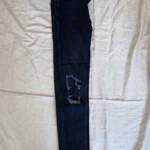 Jeans - Svarta jeans med hål på båda knäna. Loose fit (”mom jeans”) storlek xs. Från Gina tricot