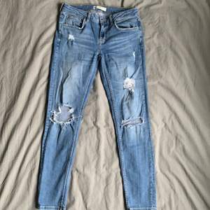 Blåa jeans med slitningar. Använda 3 gånger, mycket bra skick! Passar en S/M