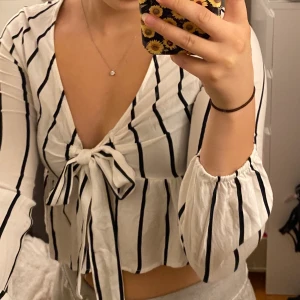 Blus med knyte  - Jättegullig randig blus köpt från pacsun. Storlek xs, skulle även passa en liten s. Säljer för 100kr. 