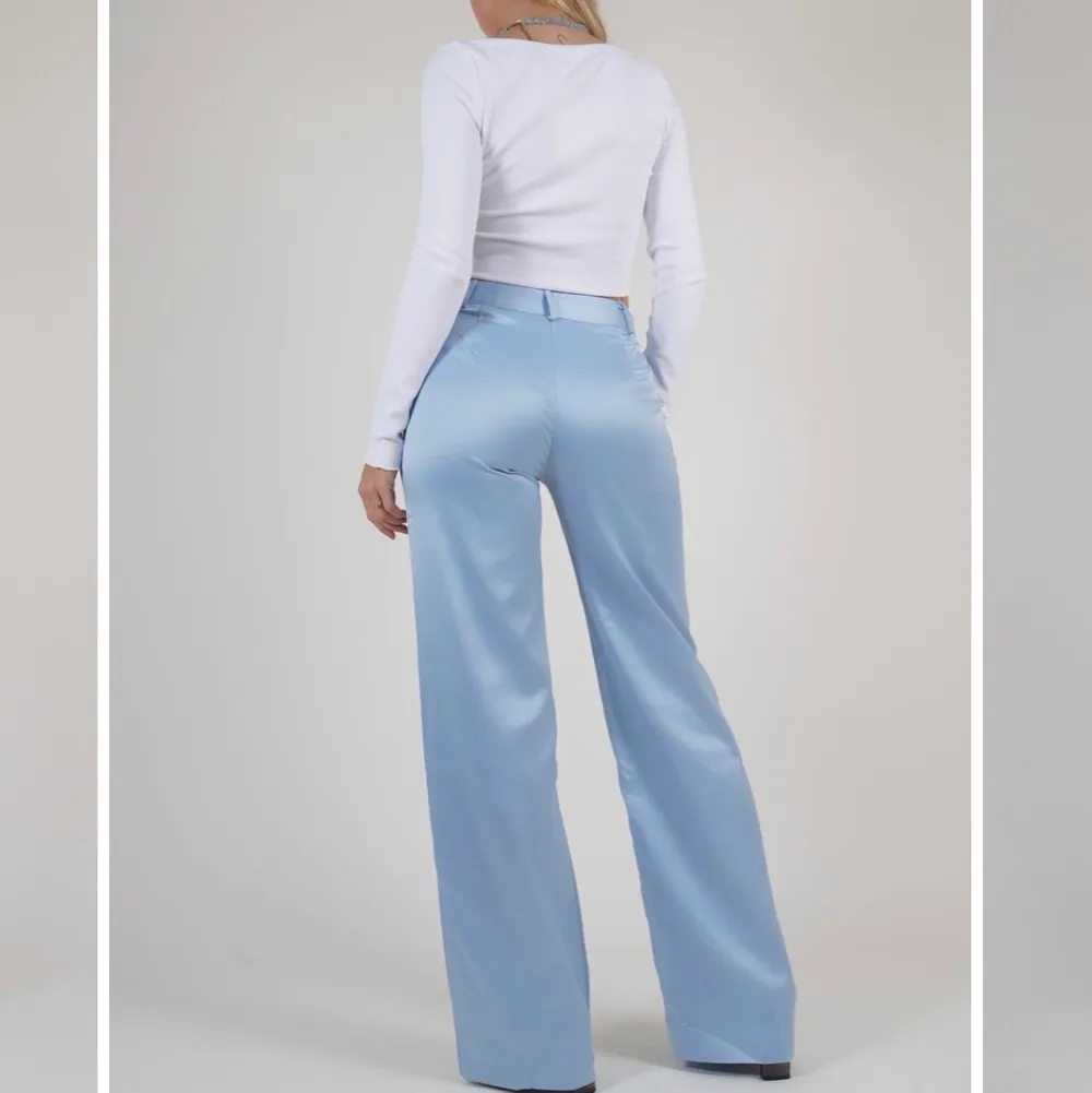 Säljer dessa fina satin byxorna i en härlig blå färg då de tyvärr inte kommer till användning längre, helt slutsålda på hemsidan. Modellen på bilden bär en xs. Jeans & Byxor.