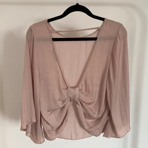 Topp med öppen rygg - Fin topp/blus i silkesmaterial i gammalrosa med öppen rygg. Storlek 36 men passar också 38.