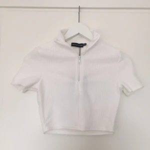 Prettylittlething zip croptop - En så fin å fräsch vit croptop med dragkedja och polokrage från prettylittlething. Helt ny med alla tags kvar 💕 Storlek 36.