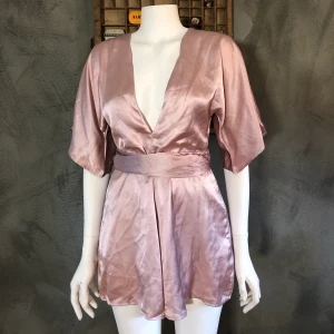 NA-KD Playsuit - En gullig, rosa, silkeslen playsuit från NA-KD. Storlek 36 men passar även dom som bär storlek 38! Helt oanvänd, fräscht skick. 