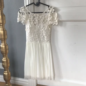 Vit klänning - Jättefin vit klänning med spets övertill samt öppen rygg. Använd några få gånger på skolavslutningar. 