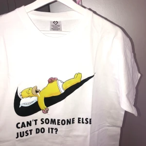 Homer Tshirt - T-shirt med nikeswosh och homer på. Heelt ny i plast bara uttagen för bilden därav man ser vikta kanterna och sista bilden. Osäker vart den är köpt (inte Nike). i storlek XXXXL, sitter oversize på mig som vanligt har S,kan sova i den. Nypris ca100kr