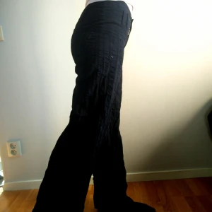 Rocky byxor - Snyggt mönstrade svarta Rockybyxor med 90%bomull och 10%viskos. Sitter som en smäck i midjan(38cmx2), snyggt över baken och sen vida ben. Hittades i garderobsrensing, önskar värdigt hem med strykbräda som kan göra de vida benen rättvisa. ;D Frakt tillkommer. Benlängd ~75cm