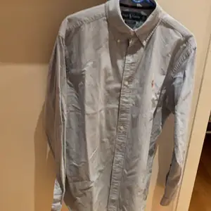 En ljusblå skjorta från Ralph Lauren, storleken L, använd ungefär 3 gånger. Exlusive frakt
