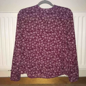  - Mönstrad blus med hög hals från Atmosphere. Dragkedja i ryggen och knapp längst ut på ärmarna.  Kan mötas upp alt. skicka.