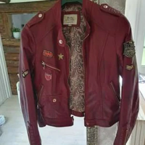 Bikerjacka - Snygg vinröd bikerjacka i fuskskinn. Storlek M men passar mer en xs-s. Jackan är i fint skick! 