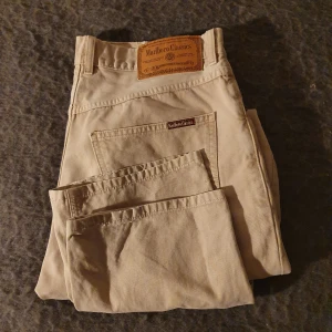 Marlboro classics  W34/L34 - Ett par fina beiga byxor i mycket bra skick säljes! Måtten på dessa är 40cm vid midjan och längden från midjan ner är ca 100cm. Frakten inkluderas i priset 🤩 Priset kan även diskuteras. Vid eventuella frågor är det bara att kontakta mig! 🥰  