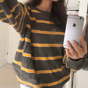  - Grå och gul randig tröja. 