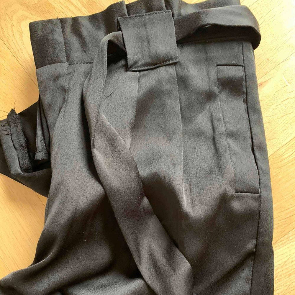 Svarta Glansiga byxor med knyt i midjan och slits i benslut, stl 38, aldrig använda, mycket fina!. Jeans & Byxor.