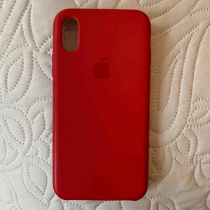  - En röd silikonskal till iPhone X. Använd så lite repor finns, se bilder.