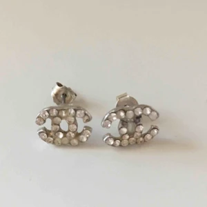  - Fina chanelörhängen Jag vågar ej garantera att de är äkta Lossnat två stenar på ena örhänget  Hämtas i Bromma eller skickas, köparen står då för frakt 