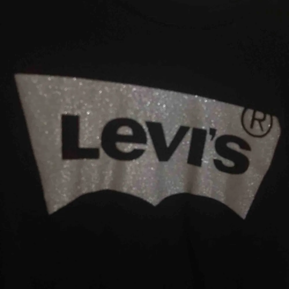 Svart Levis T-shirt med glittrigt tryck i storlek S. Knappt använd 🌟 köparen står för frakt 😊. T-shirts.