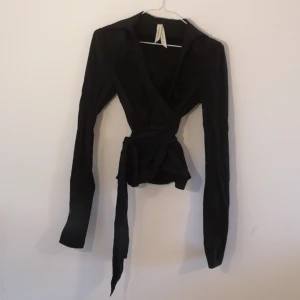  - Svart omlott-blus/skjorta, gott skick, storlek 36