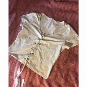  - Vit top med snörning. Storlek L. 60 kr inklusive frakt. Betalning sker via Swish. 
