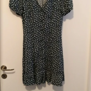 Blommig kort klänning - Blommig, kort, grön klänning från h&m, endast använd ett fåtal gånger
