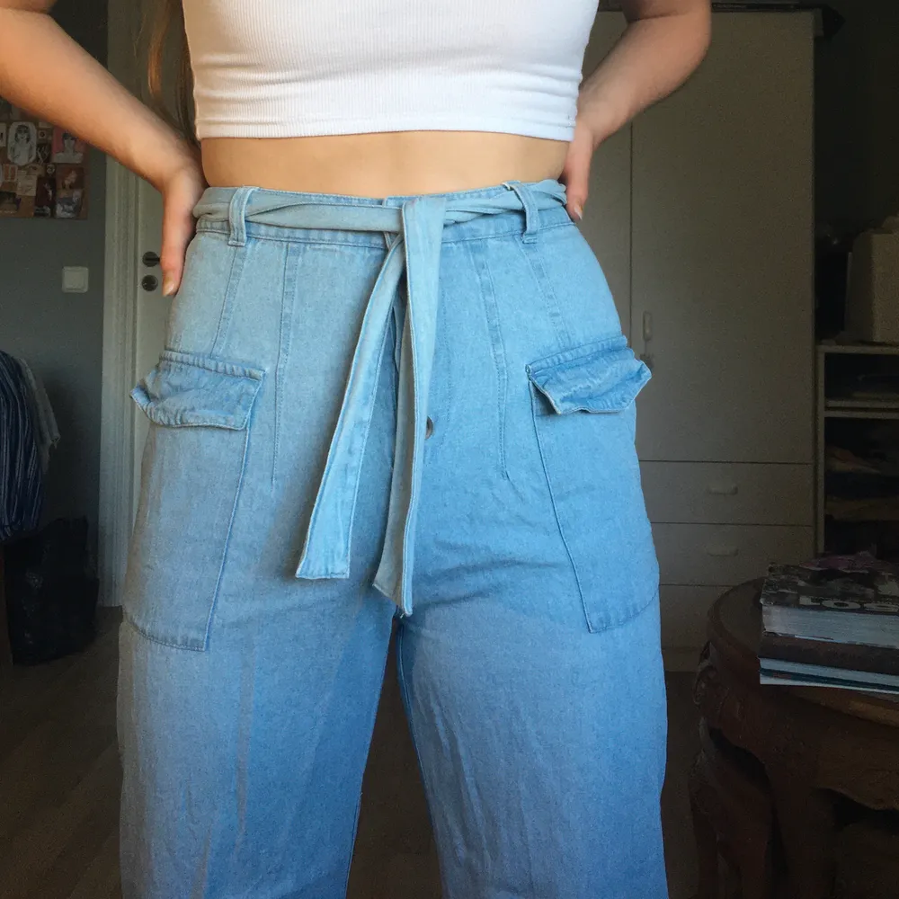 Ett par wide leg jeans i tunt tyg från asos med sidofickor och bälte. De är i storlek 38.. Jeans & Byxor.